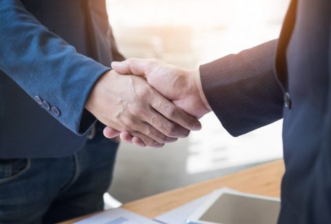 Two confident business man shaking hands during a meeting in the