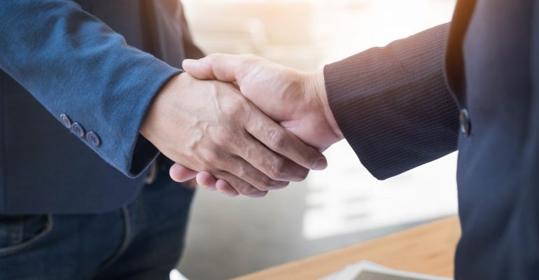 Two confident business man shaking hands during a meeting in the