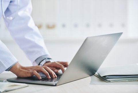 maos-da-medica-irreconhecivel-usando-laptop-no-escritorio